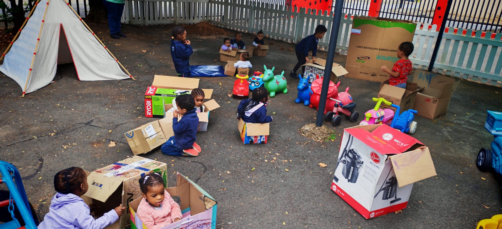 Children enjoying imaginative outdoor box play at Ladybuggz Preschool