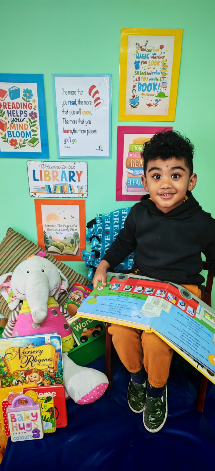 A child reading a book in the Ladybuggz library corner