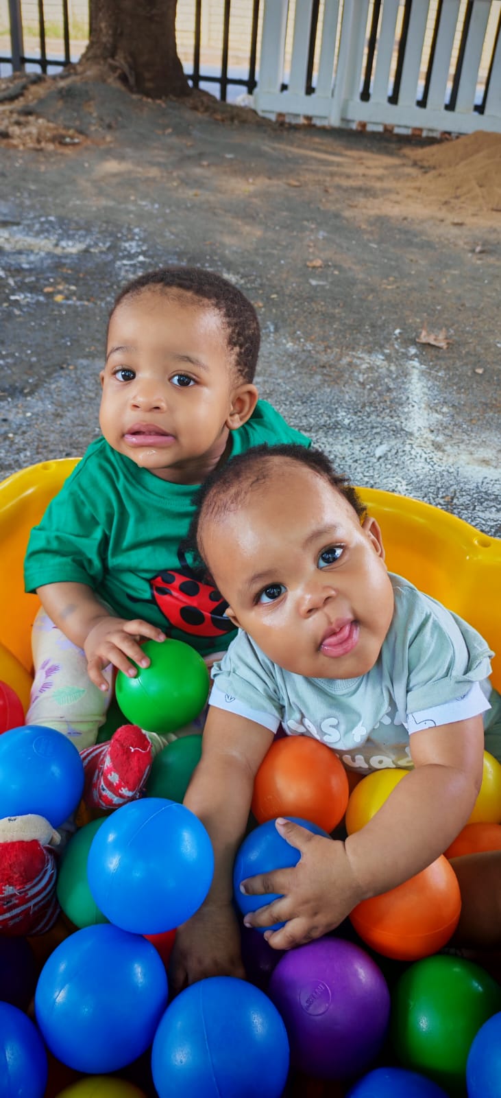 Two children enjoying supervised ball-pit play at Ladybuggz Preschool